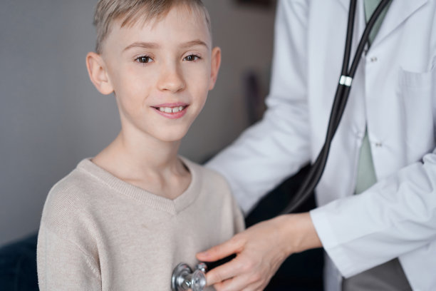 医生和快乐微笑的孩子男孩病人在家体检。医学，保健概念图片下载