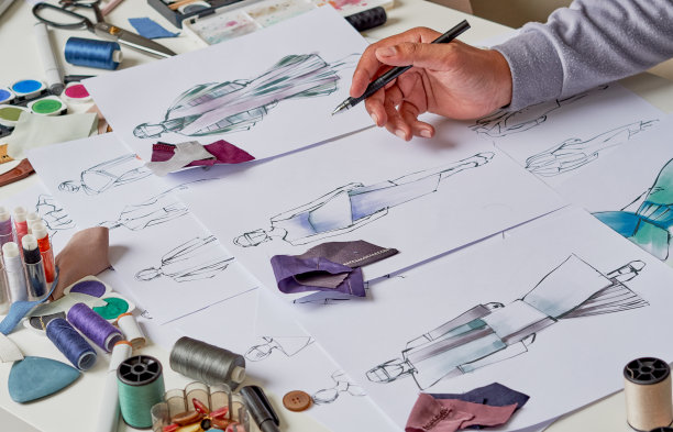 时装设计师时尚的图纸草图纺织品面料材料服装。设计师创意工作室。图片下载