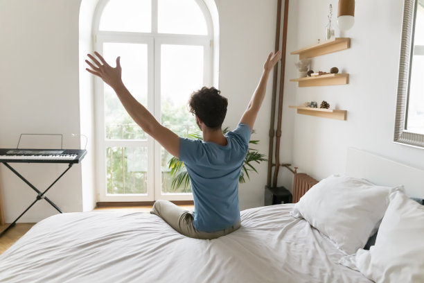 积极兴奋的年轻人在卧室享受早安，图片下载