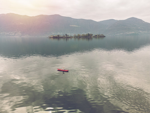 女人在平静的湖面上划独木舟，无人机鸟瞰图图片下载