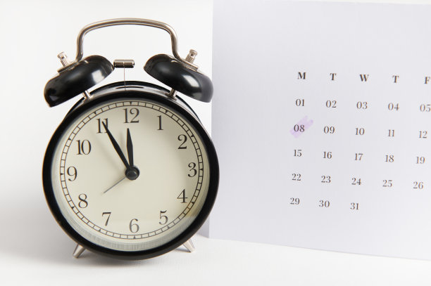 白色日历，标有日期3月8日和黑色闹钟在白色背景。妇女节提醒图片下载