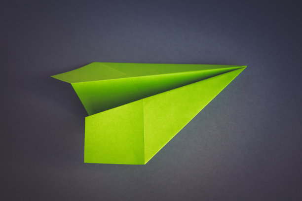 绿色的纸飞机折纸孤立的灰色背景图片下载