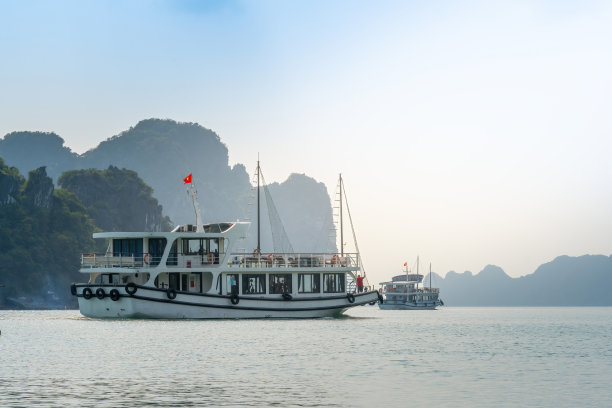 越南广宁省下龙湾景观;有很多石灰岩小岛和游轮;在一个蓝天的夏日图片下载