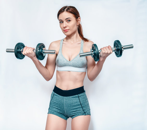 性感微笑的女人哑铃在运动短裤和顶部。白色背景。身体积极的。图片下载