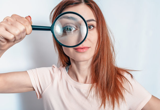 放大镜。可爱的女人在眼睛附近拿着放大镜。研究，眼病，治疗图片下载