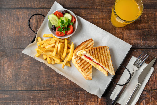 吐司、切达干酪、土耳其香肠、薯条和沙拉放在木桌上图片下载