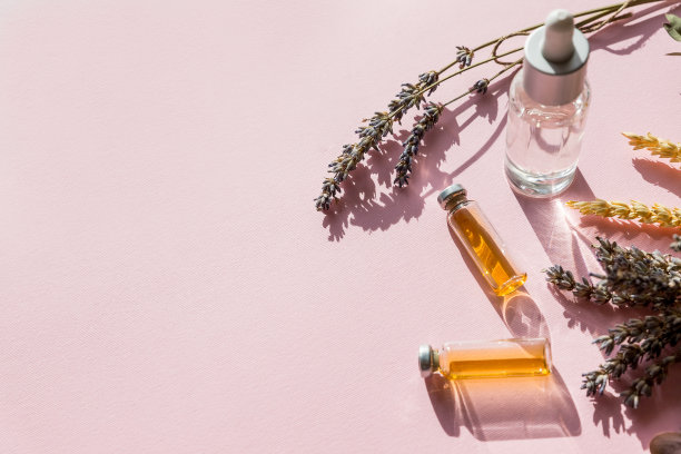 一瓶新鲜草药鼠尾草，薰衣草精油。平铺在粉红色的背景上。健康的油。素食的概念健康，排毒。替代医学，植物疗法，草药治疗。图片下载