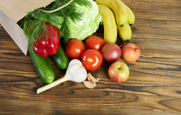 水果和蔬菜装在纸袋里，背景是木制的。送货上门的快递员。图片下载