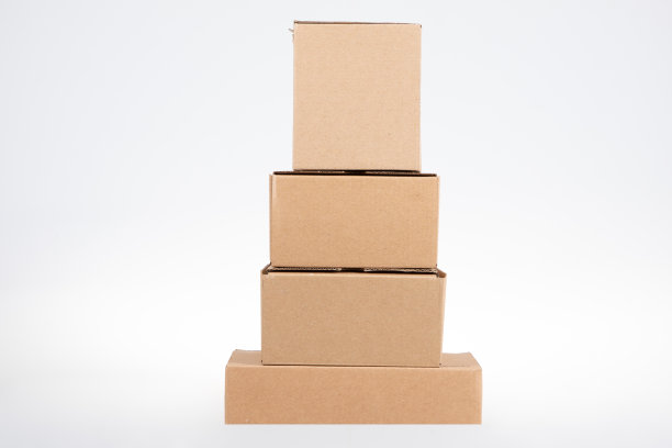 在白色背景上堆叠金字塔形的四个不同大小的纸箱图片下载