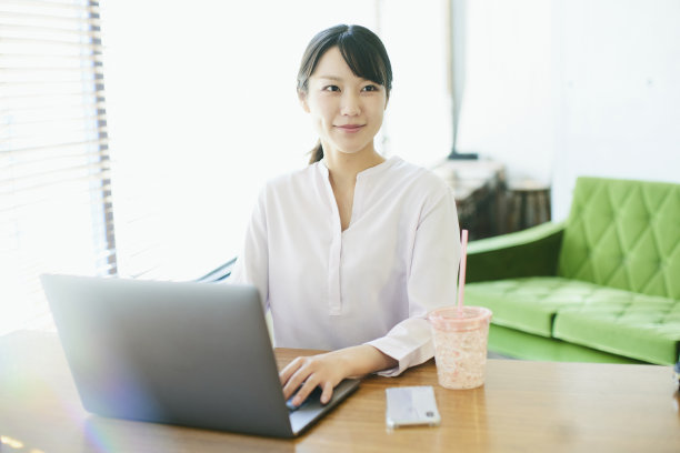 年轻的亚洲女人在靠窗的办公室工作图片下载