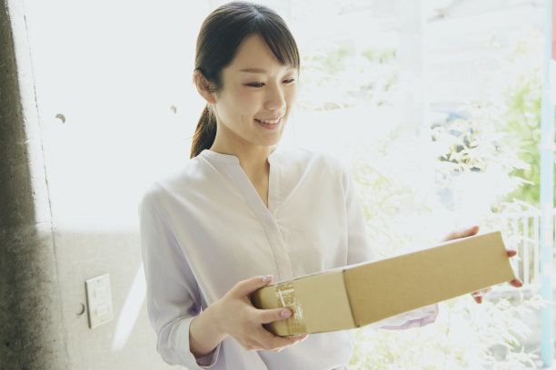 一名日本女子从快递员那里收到包裹。图片下载