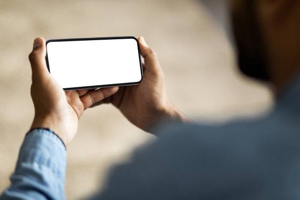 在家手持空白智能手机的非裔美国人图片下载