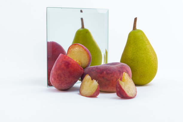 白色背景上隔离的镜子附近的梨和扁桃特写图片下载