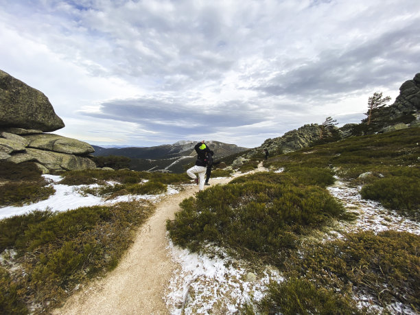 一个旅行者在部分被雪覆盖的岩石景观上的惊人镜头图片下载