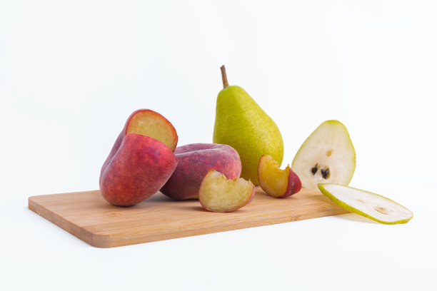 特写梨和扁平桃子在木板上孤立的白色背景图片下载