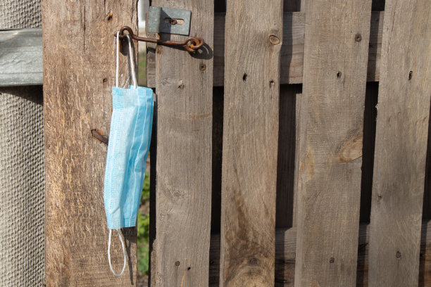 在隔离期间，乌克兰街头一扇旧木门的钩子上挂着医用口罩图片下载