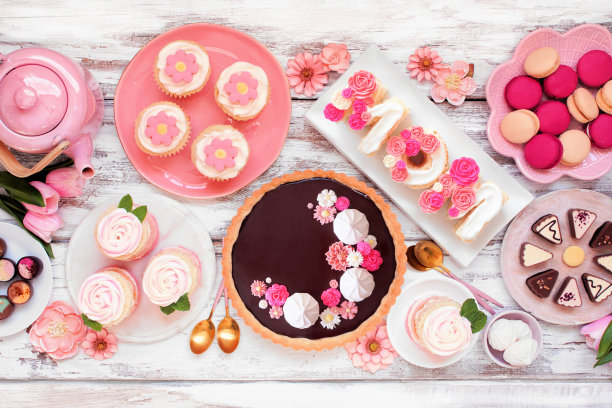 母亲节餐桌上摆放着各式各样的甜点和糖果，上面是白色的木头图片下载