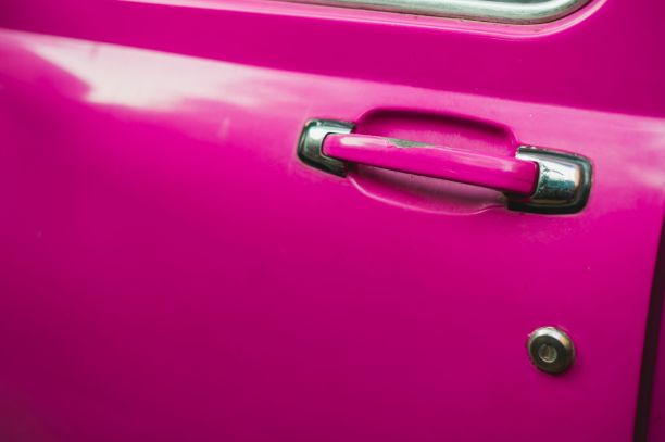 一辆粉色复古车的门把手特写镜头图片下载