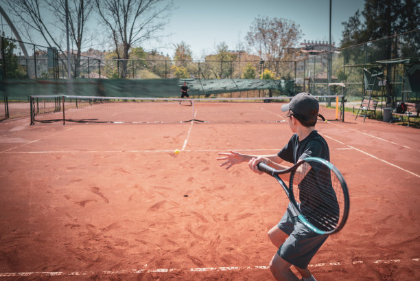 男子网球运动员在夜间比赛或练习中反手和正手击球的特写后视图图片下载