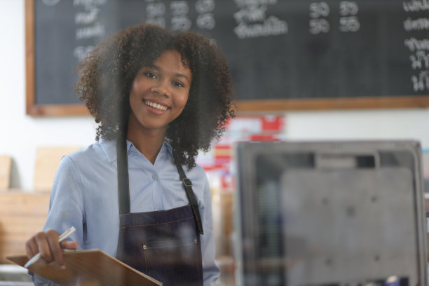 年轻的非洲女性小企业主在咖啡馆工作。在咖啡店工作的员工。图片下载