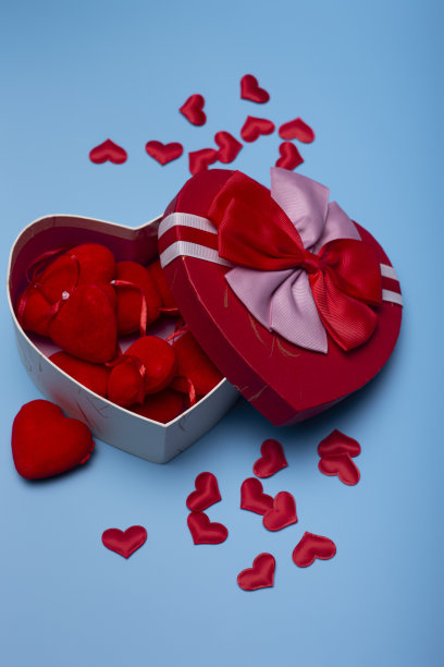 垂直拍摄的心形盒子充满了孤立的心脏在蓝色背景图片下载