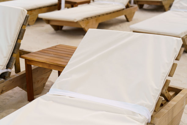 沙滩上日光浴床的特写图像。日光浴床和沙滩主题的暑假照片。图片下载