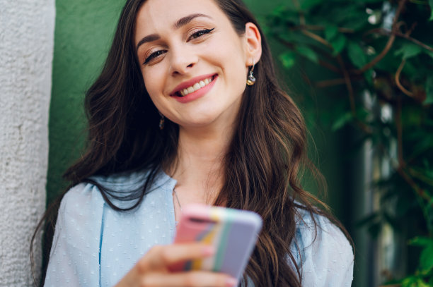 美女坐在街边咖啡馆里用智能手机图片下载