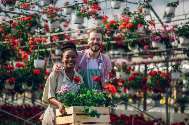 一对在温室里工作的多种族园丁夫妇的肖像图片下载