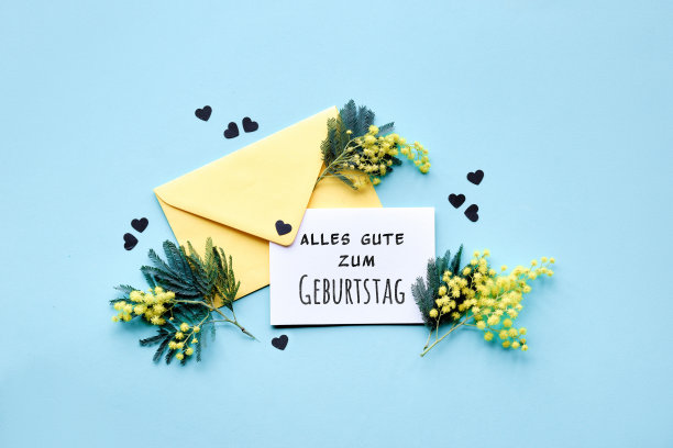 Alles Gute zum Geburtstag在德语中的意思是生日快乐。文字特别时刻贺卡含羞草花在黄色信封上蓝色背景，五彩纸屑。图片下载