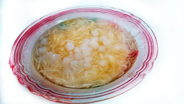 黄色哈密瓜汤配西瓜和椰子豆，玻璃碗，白色背景图片下载