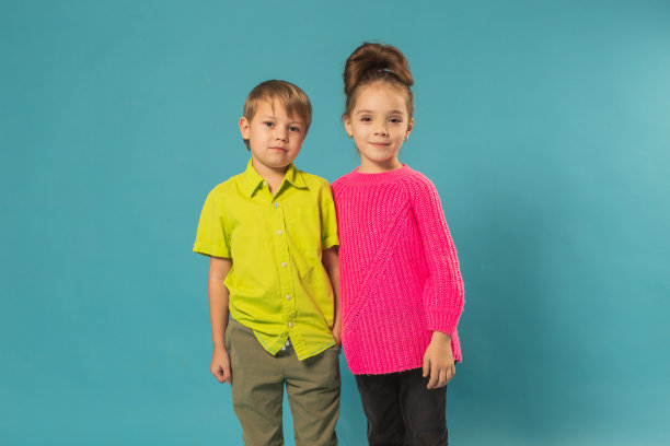 男孩和女孩在蓝色背景的工作室图片下载