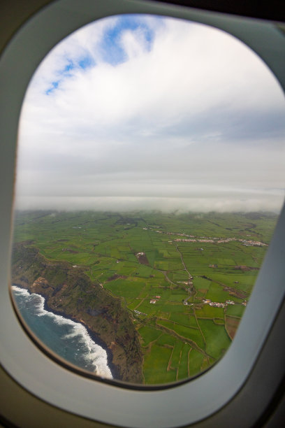 这张照片是在飞机窗口拍摄的，可以看到有海洋和云层的岛屿。图片下载