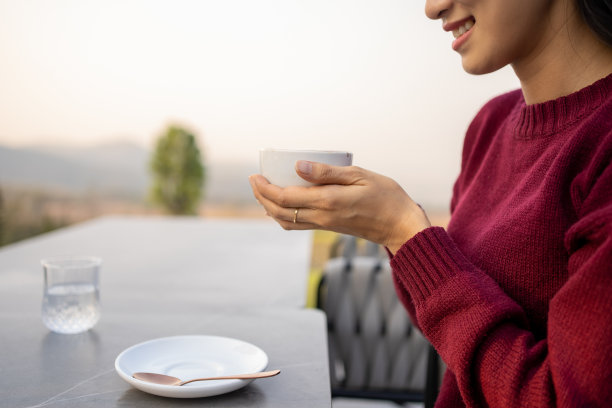 假日期间，亚洲女子在山上喝着热咖啡，享受着风景，具有假日概念。在山上喝咖啡。图片下载