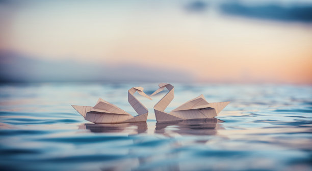 河面背景天空上的折纸鸟。图片下载