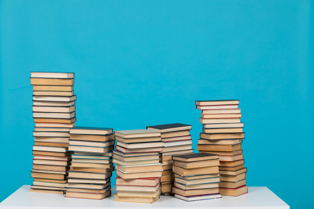 在图书馆的知识室里，在蓝色背景上阅读大量的科学书籍图片下载