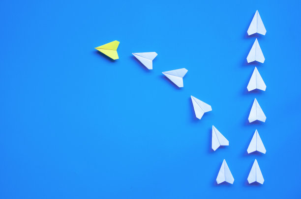 黄色纸飞机折纸引领其他白色飞机在蓝色背景与自定义空间的文字或想法的俯视图。领导技能的概念和复制空间图片下载