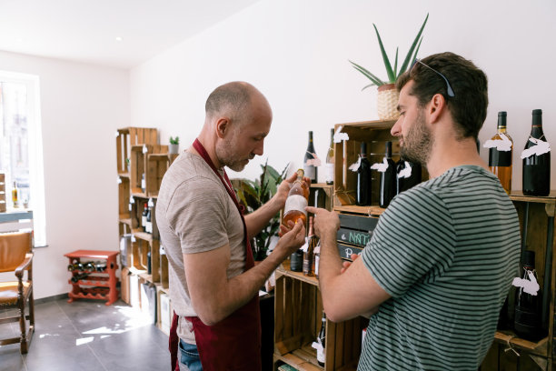 酒窖老板正在向顾客讲解葡萄酒的相关知识，顾客是一家卖酒的酒铺的员工，酿酒师和侍酒师图片下载