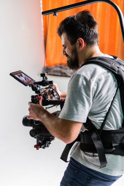 摄影棚里的摄影师使用的是带稳定器的专业相机图片下载