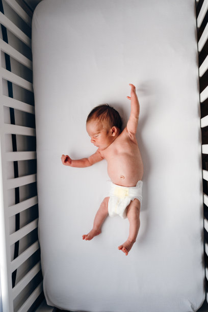 小男孩在婴儿床上伸展身体图片下载