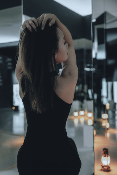 穿着黑色运动服的女人们在室内的玻璃镜子前锻炼图片下载