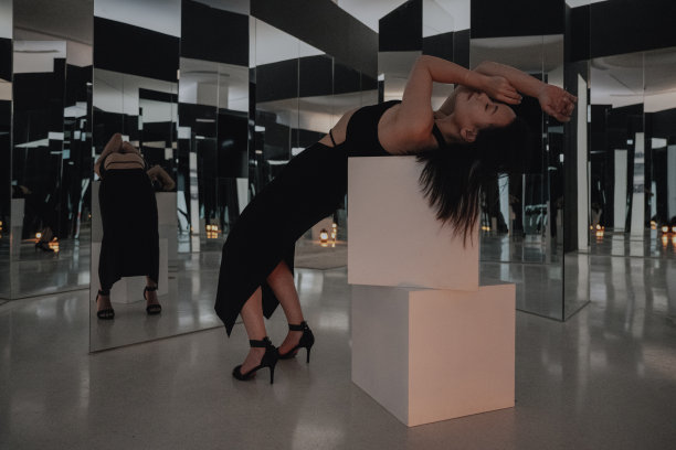 穿着黑色运动服的女人们在室内的玻璃镜子前锻炼图片下载