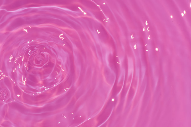 离焦模糊透明紫色颜色清澈平静的水面纹理与飞溅，气泡。闪闪发光的紫色水波纹背景。游泳池的水面。紫色泡泡水闪闪发光。图片下载