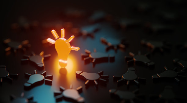 在黑色背景上的黑色灯泡符号中发光的橙色灯泡符号图片下载