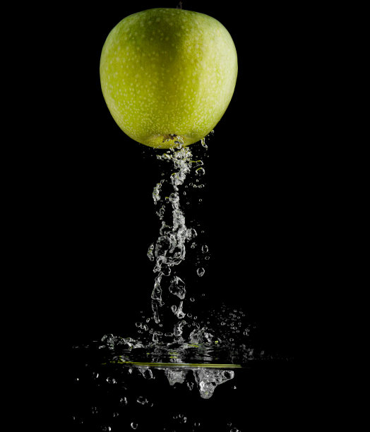 苹果在黑色背景下落入水中图片下载