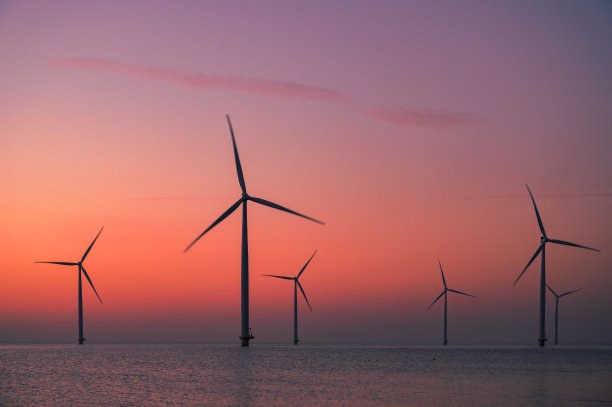 海上风电场的风力涡轮机在日落时发电。图片下载