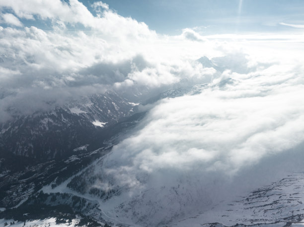 高山景观，山峰被雪和云覆盖。图片下载