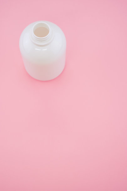 垂直拍摄的空瓶孤立在粉红色的背景图片下载