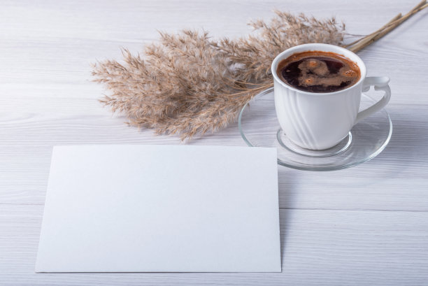 模板与相框或白纸放在木桌上。一杯咖啡。Lagurus和干树枝的香味。阳光从窗户射进来。图片下载