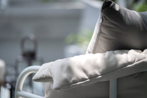 靠近白色灰色软枕头靠垫安排在自然材料餐椅与模糊天井区域背景室内设计概念图片下载