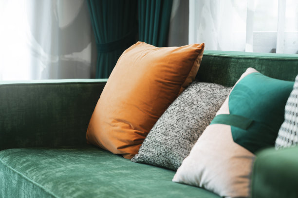 客厅中沙发沙发的靠垫枕头图案布置家居创意室内概念，枕头设计通过透明和窗帘在沙发上以晨光遮阳放松随意排列图片下载